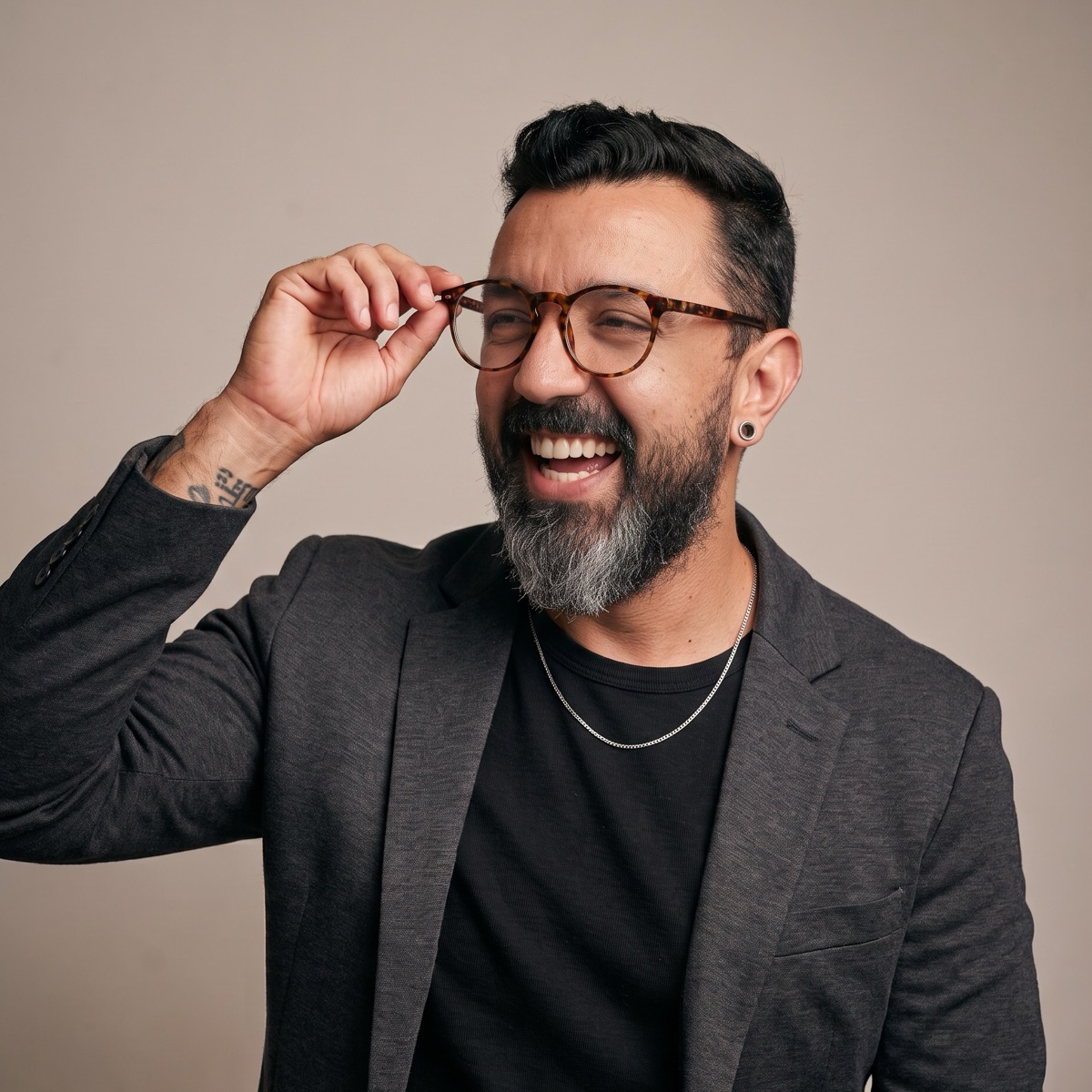 Retrato de Paulo Gontijo sorrindo, ajustando os óculos